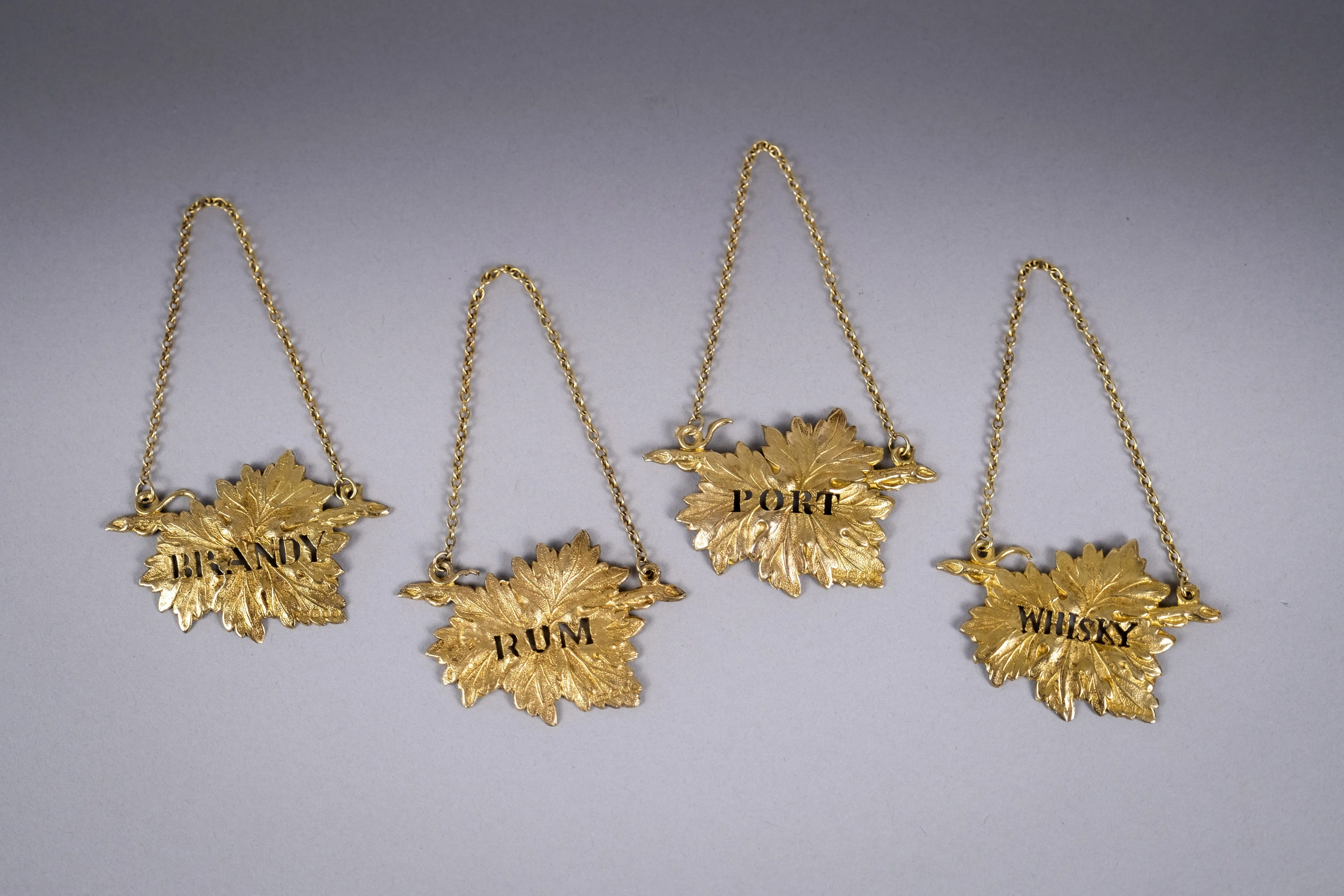 Four Silver Gilt Vine Leaf Decanter Labels by SMD, London, 1968.