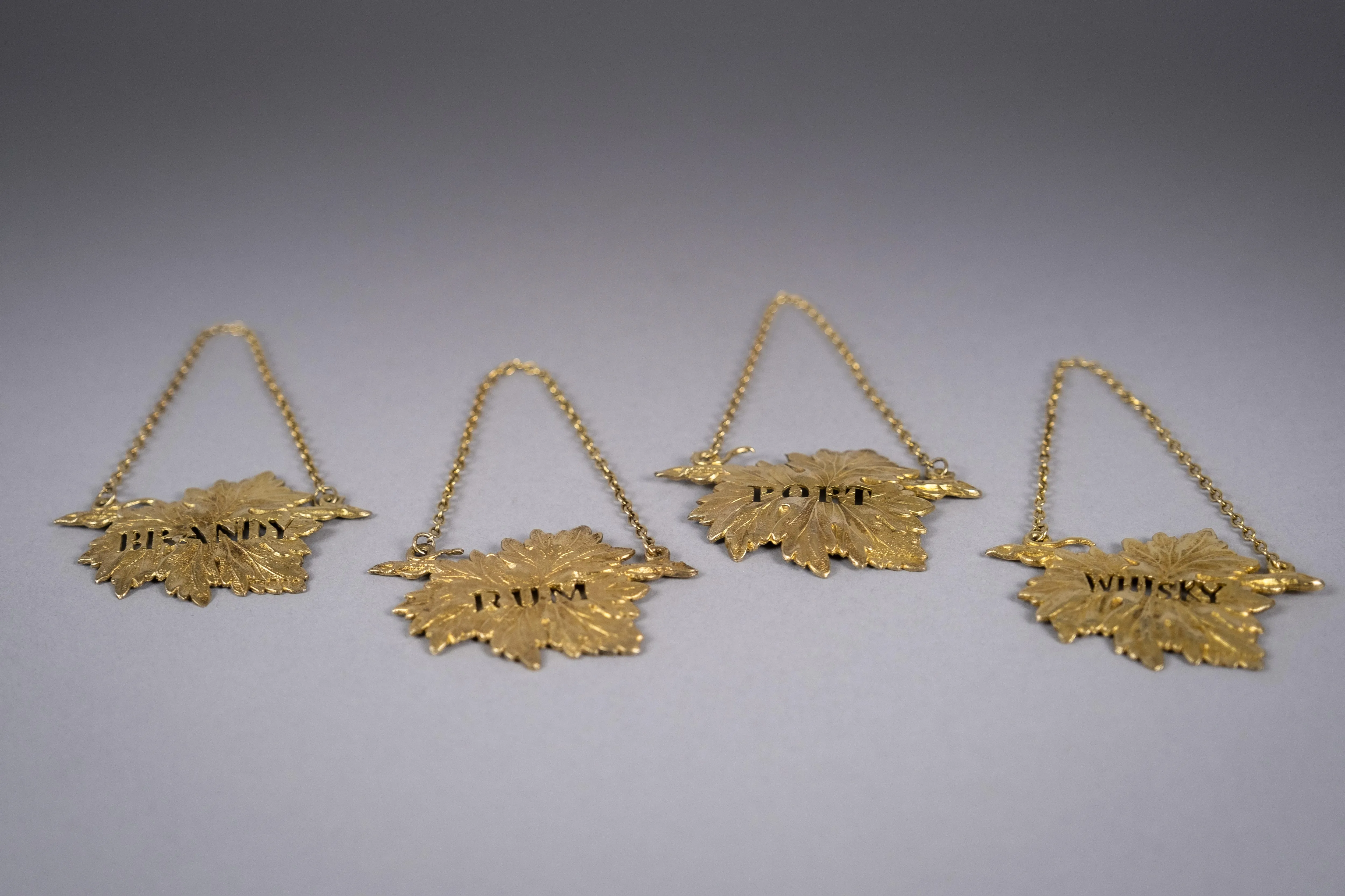 Four Silver Gilt Vine Leaf Decanter Labels by SMD, London, 1968.