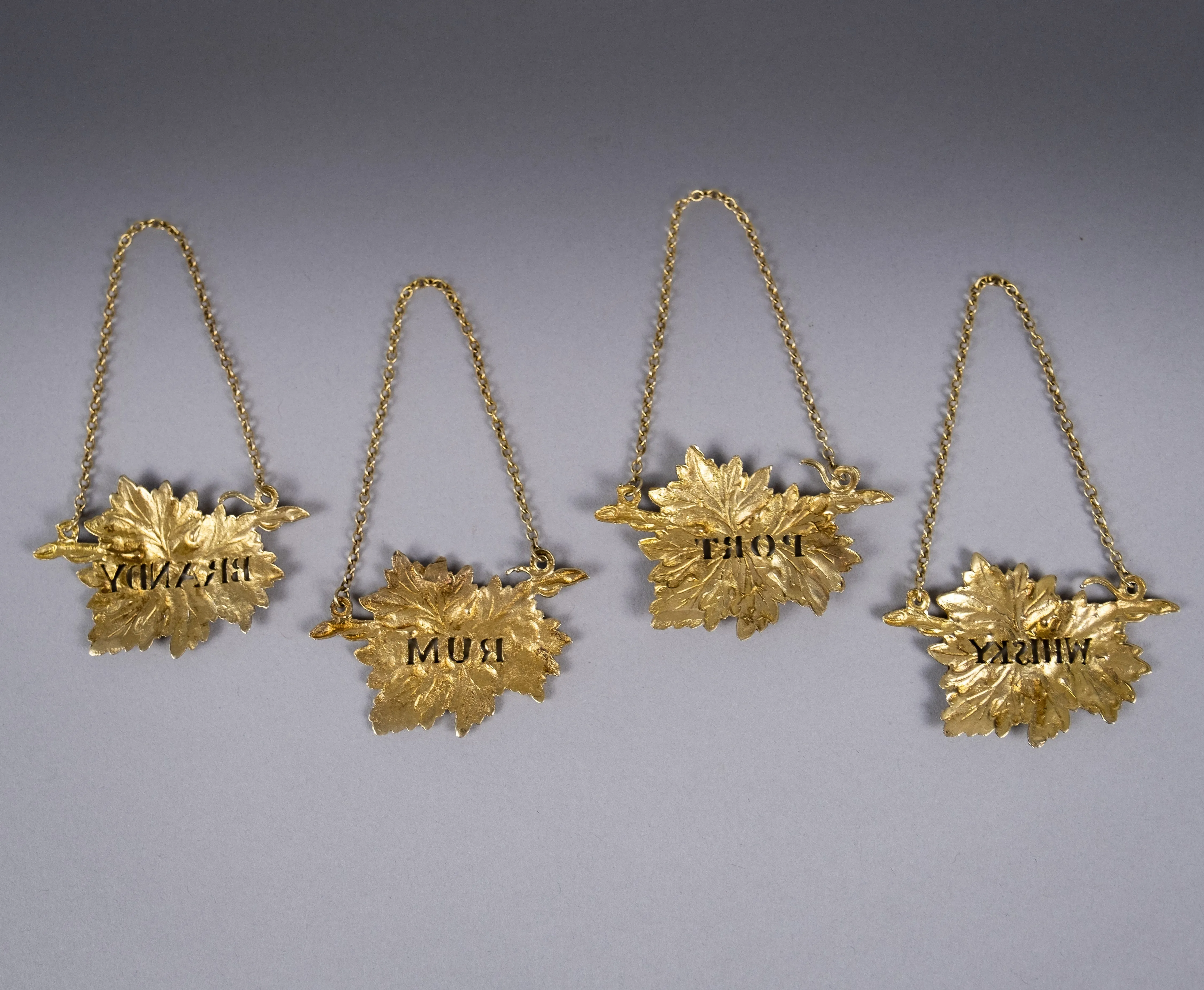 Four Silver Gilt Vine Leaf Decanter Labels by SMD, London, 1968.