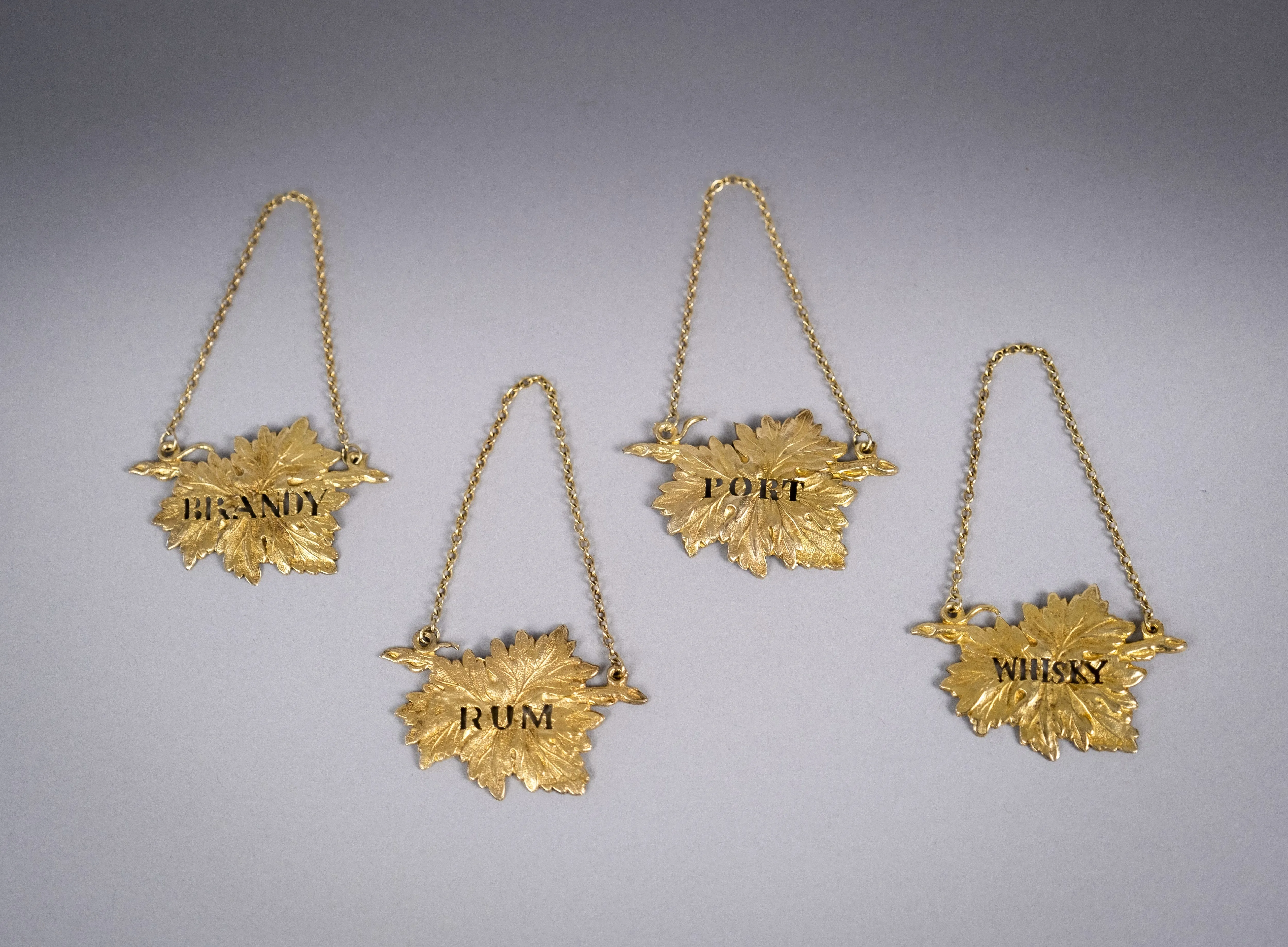 Four Silver Gilt Vine Leaf Decanter Labels by SMD, London, 1968.